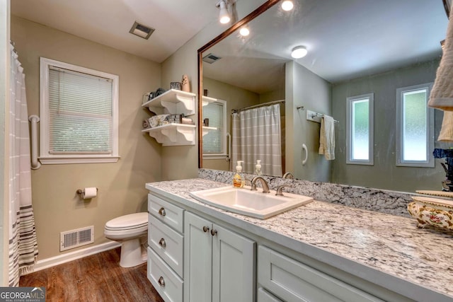 bathroom with wood-type flooring, vanity, and toilet