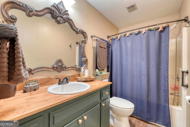 full bathroom with hardwood / wood-style floors, shower / tub combo with curtain, vanity, and toilet