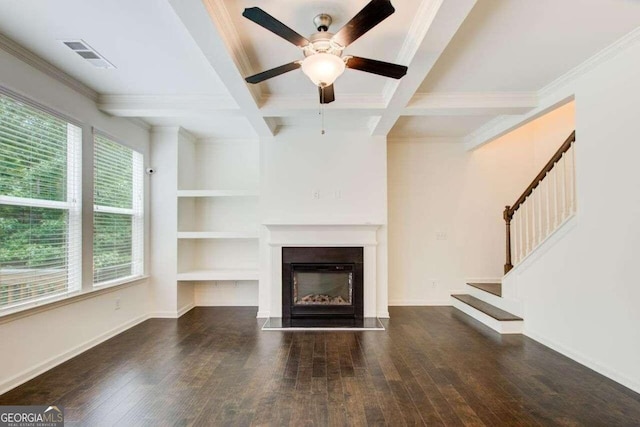 unfurnished living room featuring beamed ceiling, dark hardwood / wood-style floors, ceiling fan, and plenty of natural light