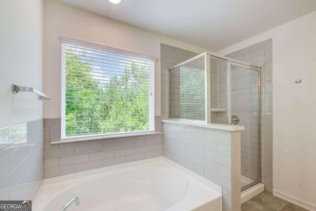 bathroom featuring independent shower and bath and plenty of natural light