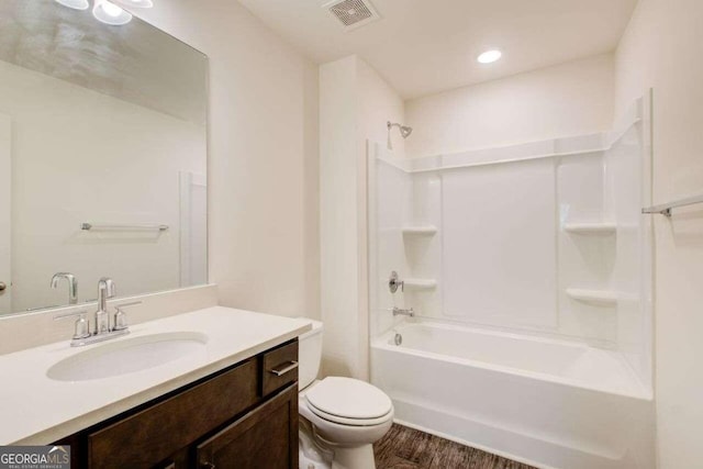 full bathroom with hardwood / wood-style floors, bathing tub / shower combination, vanity, and toilet