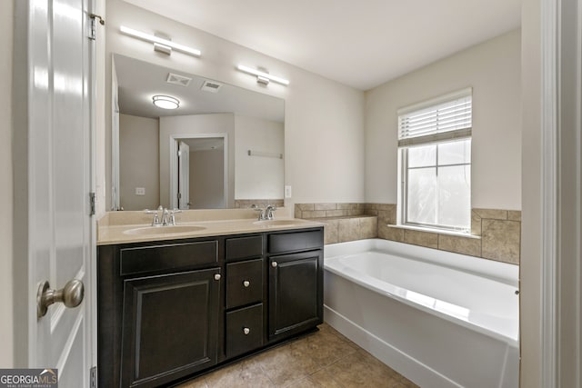 bathroom featuring tile patterned floors, a bathing tub, and vanity