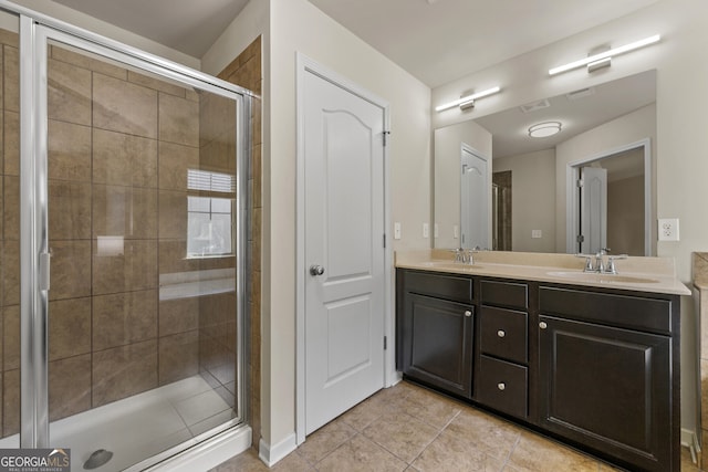 bathroom featuring tile patterned flooring, vanity, and a shower with shower door