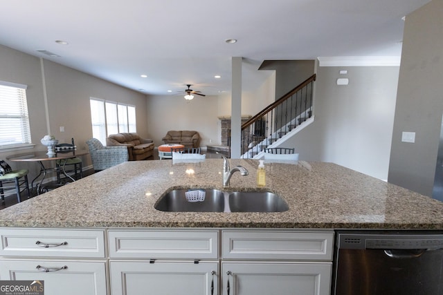 kitchen with light stone countertops, dishwasher, white cabinetry, ceiling fan, and sink