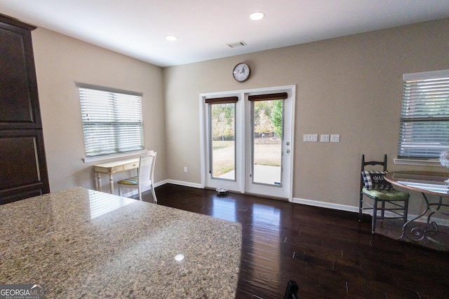 kitchen featuring dark hardwood / wood-style flooring, dark brown cabinetry, and light stone countertops