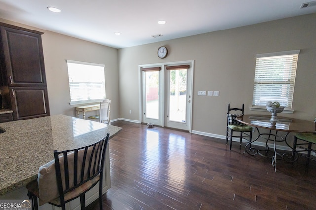 kitchen featuring light stone countertops, dark brown cabinets, and dark hardwood / wood-style flooring