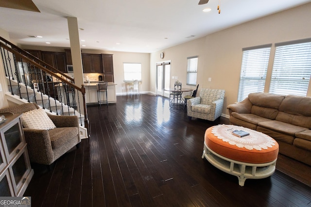 living room featuring ceiling fan and dark hardwood / wood-style floors