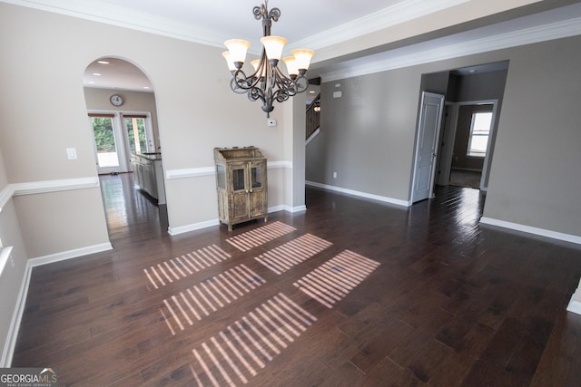 interior space featuring ornamental molding, dark wood-type flooring, and a notable chandelier