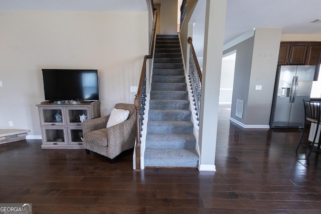 staircase with crown molding and wood-type flooring