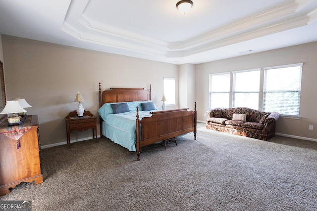 bedroom with ornamental molding, dark colored carpet, and a tray ceiling