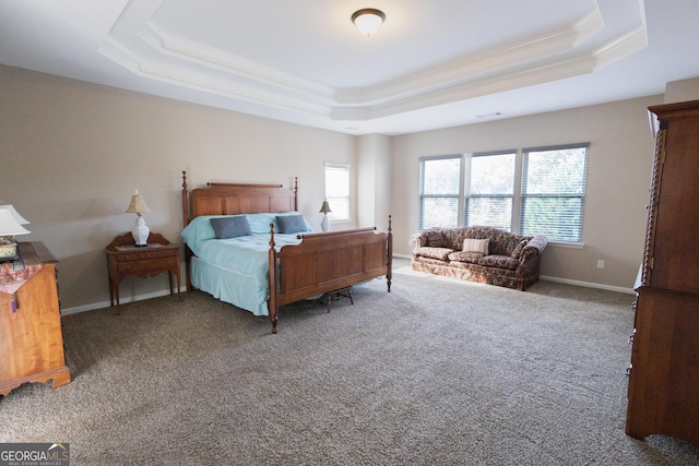 bedroom with carpet flooring, ornamental molding, and a tray ceiling