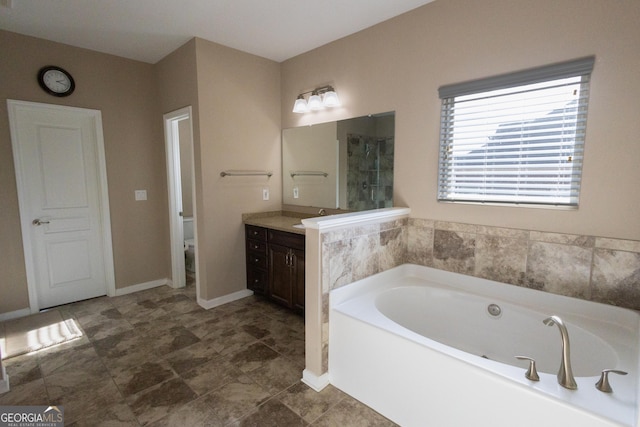 bathroom featuring toilet, vanity, and a tub