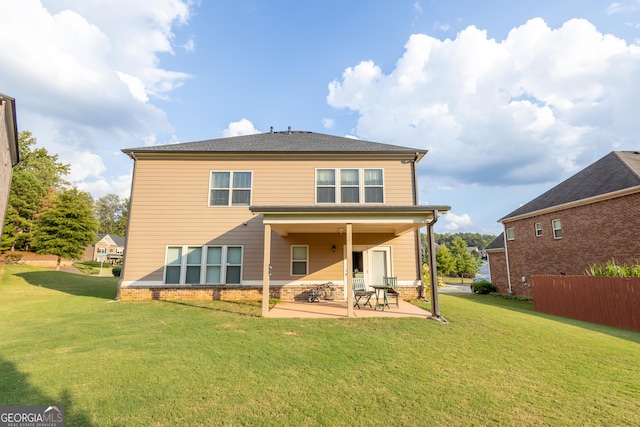 rear view of house featuring a yard and a patio