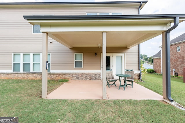 rear view of property featuring a patio and a lawn