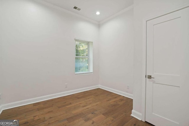 empty room featuring crown molding and dark hardwood / wood-style flooring