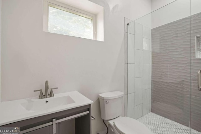 bathroom with a shower with door, toilet, and vanity