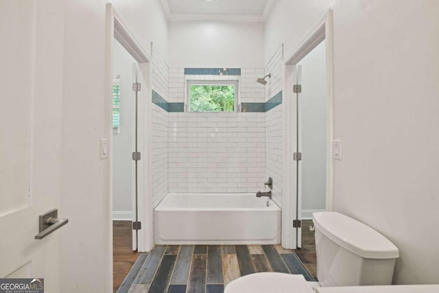 bathroom featuring tiled shower / bath, crown molding, toilet, and hardwood / wood-style flooring