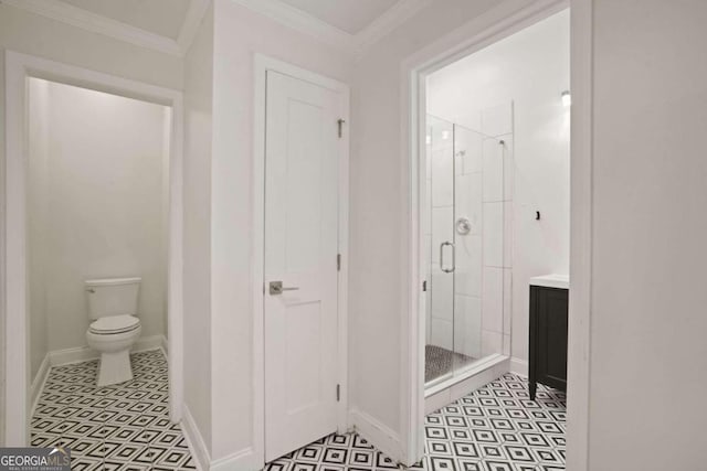 bathroom with ornamental molding, vanity, toilet, and a shower with shower door