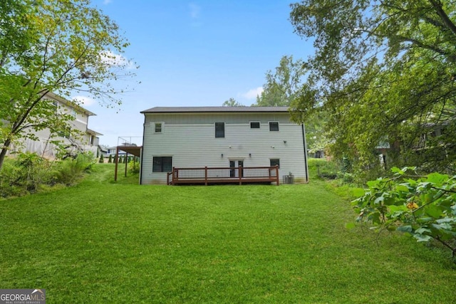 back of house with central air condition unit, a deck, and a yard