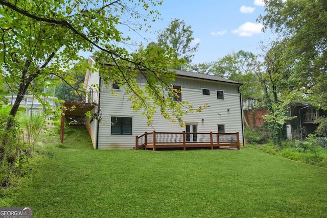 back of house with a deck and a yard