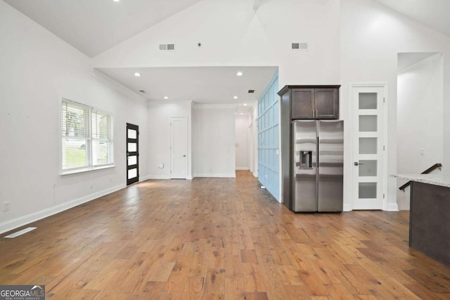 unfurnished living room with high vaulted ceiling and wood-type flooring