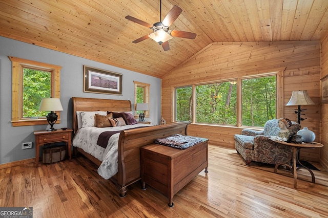 bedroom with wood ceiling, vaulted ceiling, light hardwood / wood-style flooring, wooden walls, and ceiling fan