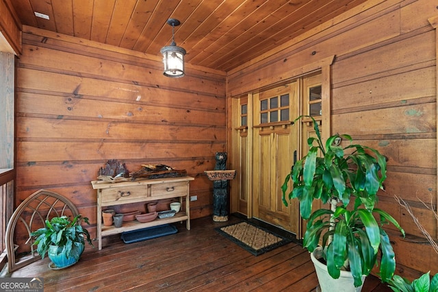 interior space featuring wooden walls, dark hardwood / wood-style floors, and wooden ceiling