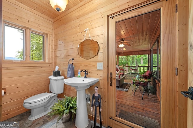 bathroom featuring wood ceiling, wood walls, and toilet