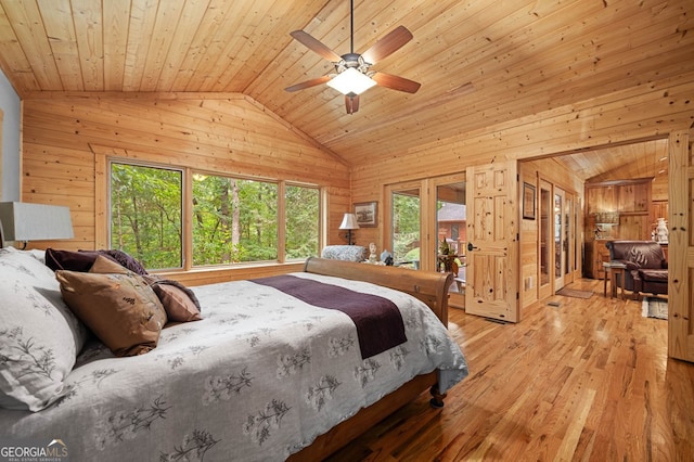 bedroom with wood ceiling, vaulted ceiling, wood walls, light hardwood / wood-style flooring, and ceiling fan