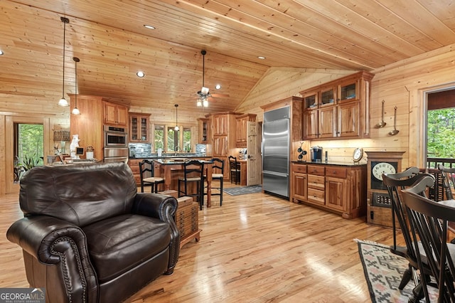 living room with ceiling fan, wood walls, high vaulted ceiling, wooden ceiling, and light wood-type flooring