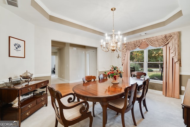 dining space featuring ornamental molding, a notable chandelier, and a raised ceiling