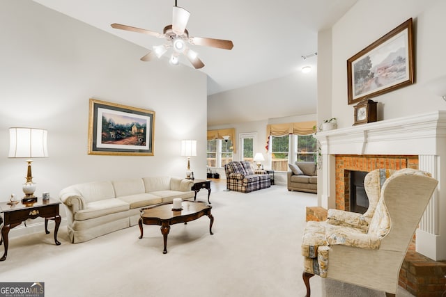 living room with vaulted ceiling, a brick fireplace, carpet floors, and ceiling fan