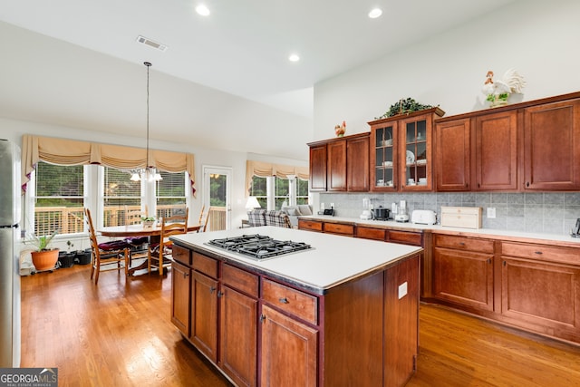 kitchen with light hardwood / wood-style floors, decorative light fixtures, appliances with stainless steel finishes, and plenty of natural light