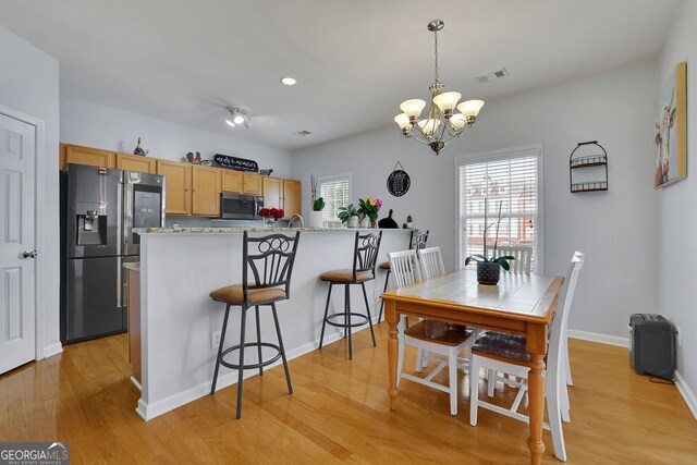 dining room featuring a notable chandelier and light hardwood / wood-style floors