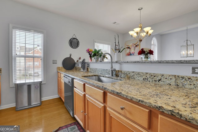 kitchen featuring dishwasher, pendant lighting, light wood-type flooring, an inviting chandelier, and sink