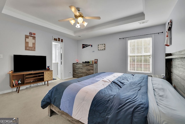 carpeted bedroom featuring ornamental molding, ceiling fan, and a raised ceiling