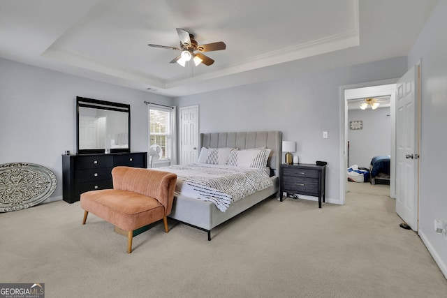 bedroom featuring ceiling fan, a raised ceiling, and light carpet