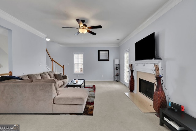 living room with crown molding, light carpet, ceiling fan, and a premium fireplace