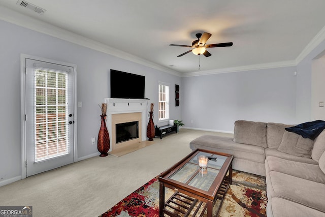 carpeted living room with ceiling fan and crown molding