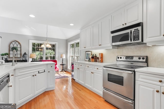 kitchen featuring stainless steel appliances, light hardwood / wood-style floors, sink, and white cabinetry