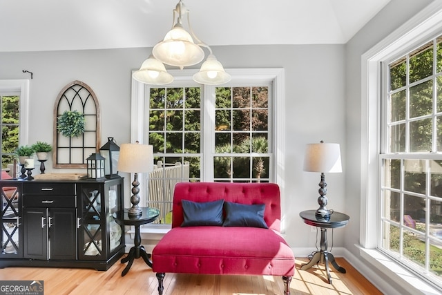 sitting room with lofted ceiling, hardwood / wood-style flooring, and a wealth of natural light