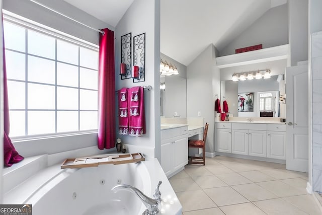 bathroom featuring tile patterned flooring, a bathtub, vaulted ceiling, and vanity