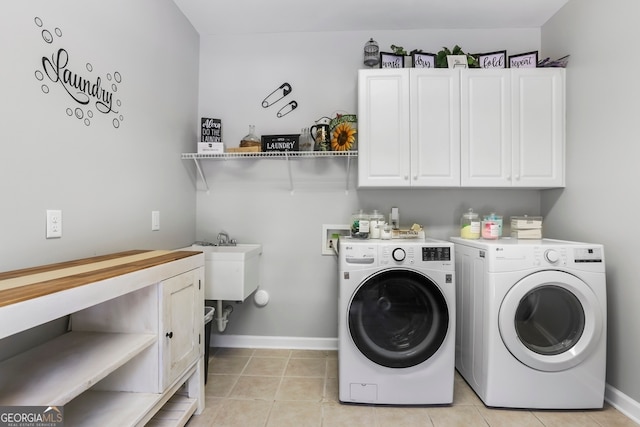 laundry area with washer and clothes dryer, light tile patterned floors, and cabinets