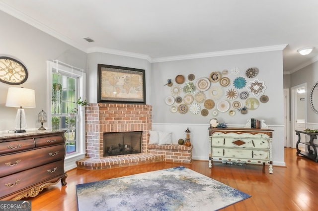 living room with a brick fireplace, a healthy amount of sunlight, and wood-type flooring