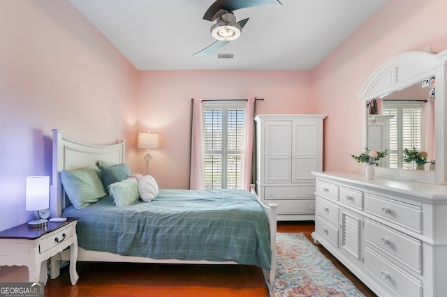 bedroom featuring multiple windows, ceiling fan, and dark hardwood / wood-style floors