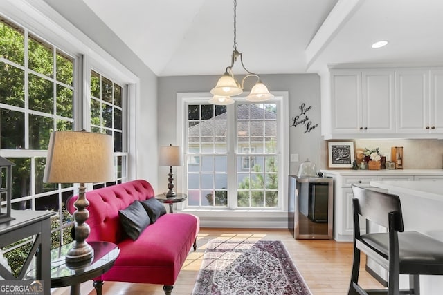 interior space with lofted ceiling, a chandelier, and light hardwood / wood-style floors