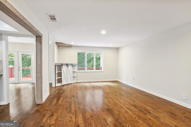 unfurnished living room with french doors, a healthy amount of sunlight, and dark hardwood / wood-style flooring