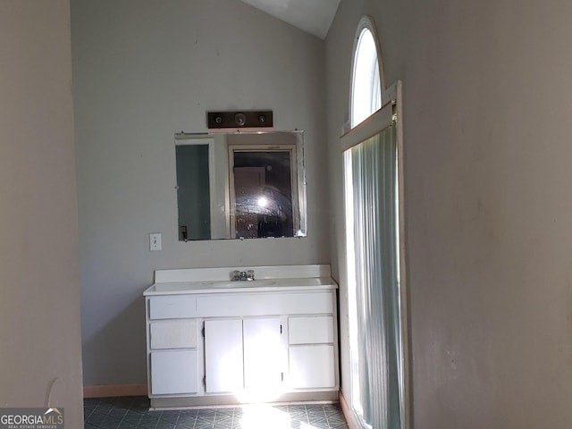 bathroom with vanity, lofted ceiling, and tile patterned flooring