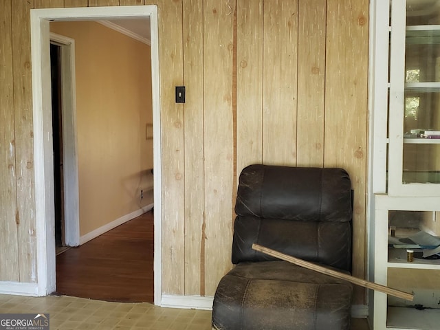 living area with hardwood / wood-style floors, crown molding, and wood walls