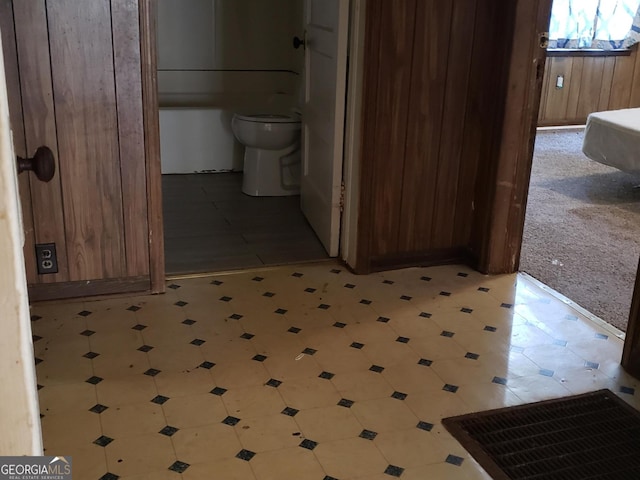 hallway featuring wooden walls